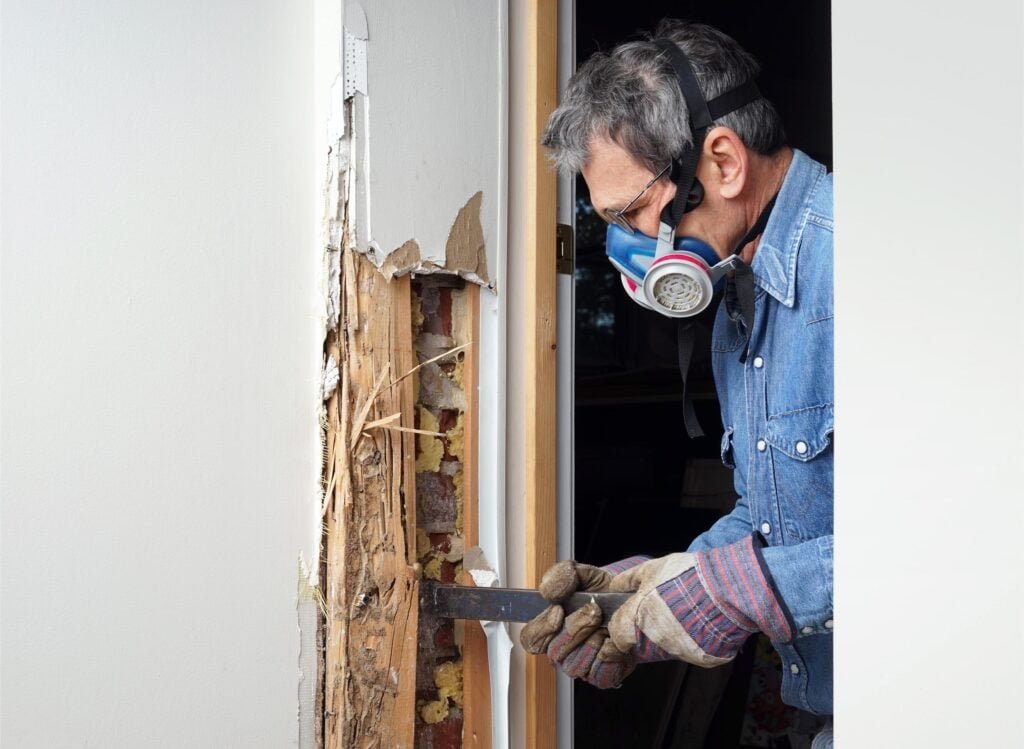 Person repairing damaged wooden door