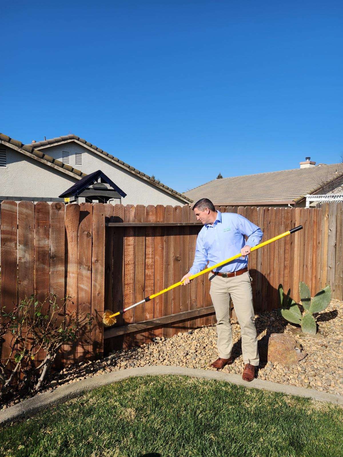 Pest control technician applying treatment outside home