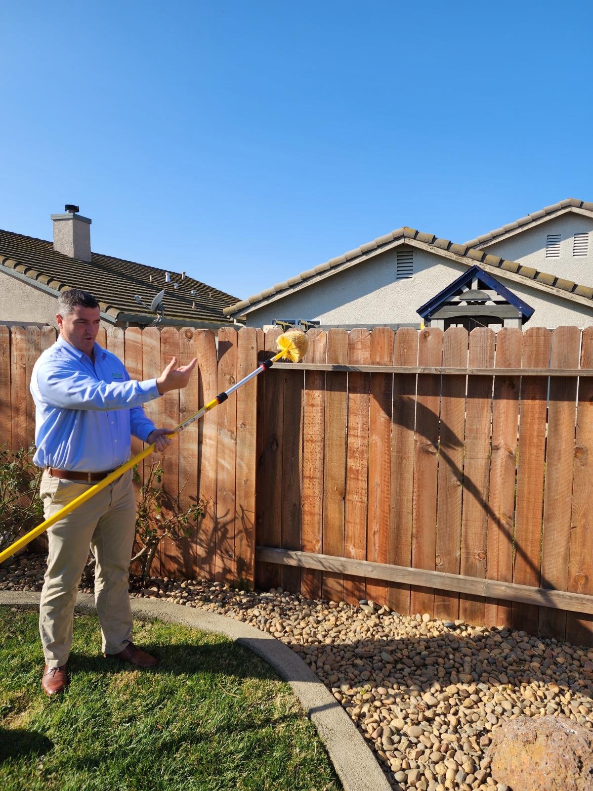 Pest control technician applying treatment outside home