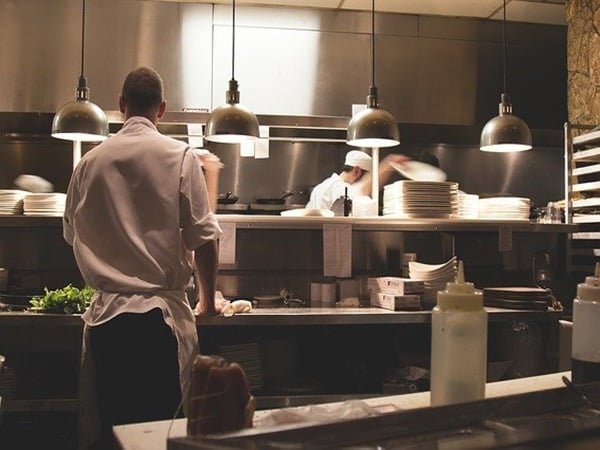 Chef in restaurant kitchen maintaining clean workspace